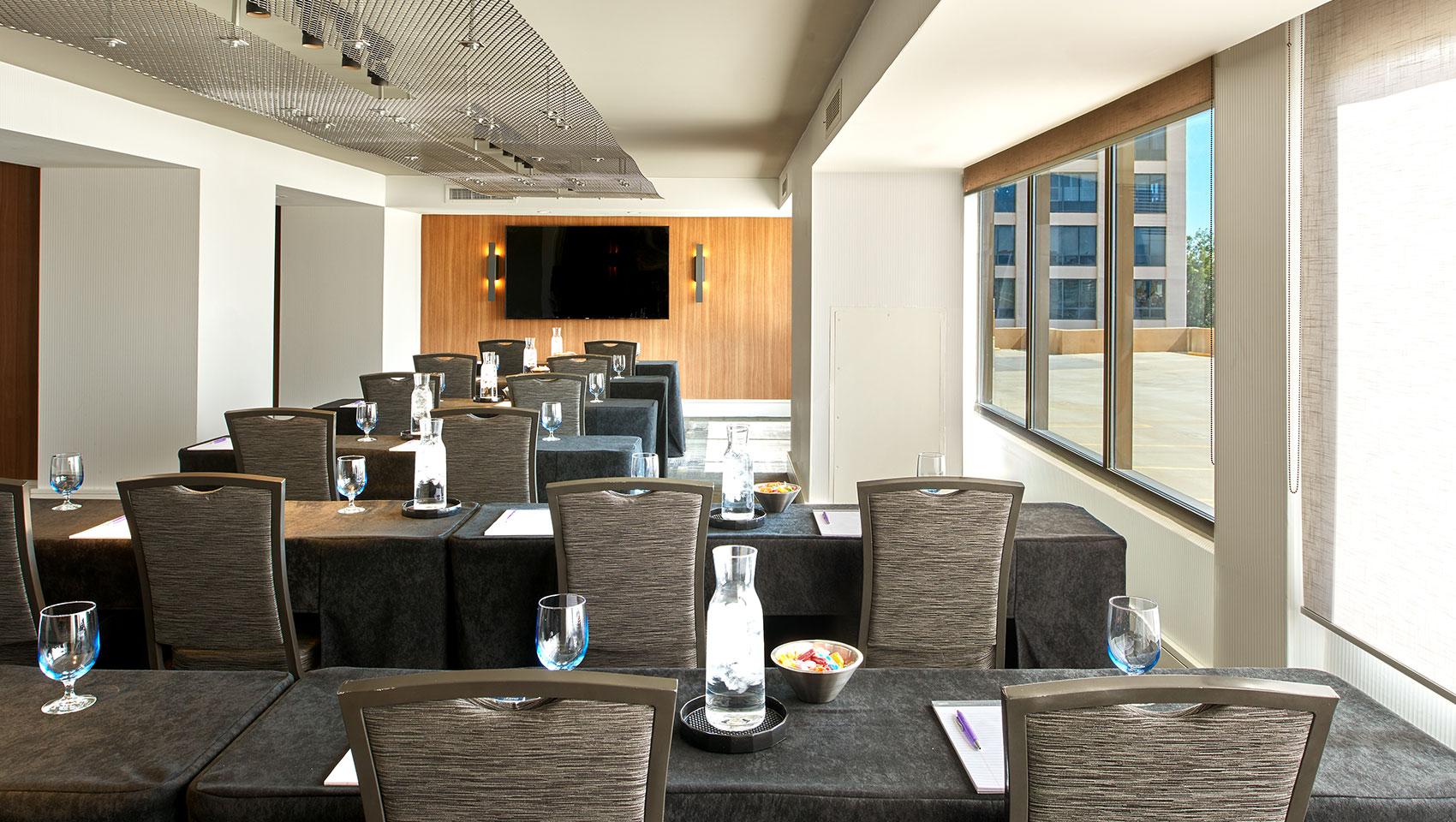 Classroom style meeting set up with tables and chairs in the LA Film Meeting Rom at Kimpton Hotel Palomar Beverly Hills