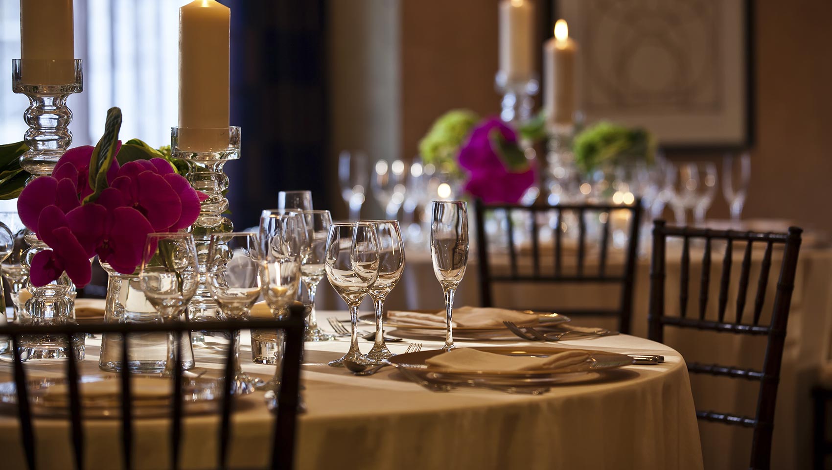 Close up of round dining table set with glasses, cutlery, dishes, and flowers for an event at Kimpton Hotel Palomar Beverly Hills
