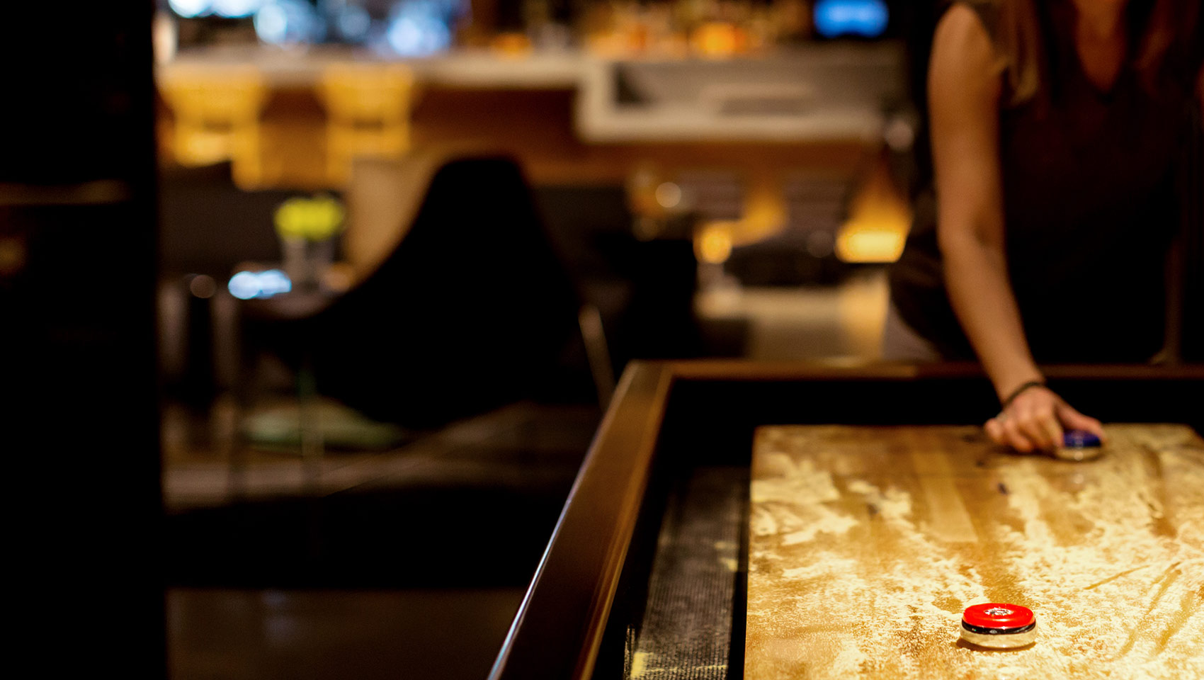 Close up of shuffle board, woman playing out of focus in the background