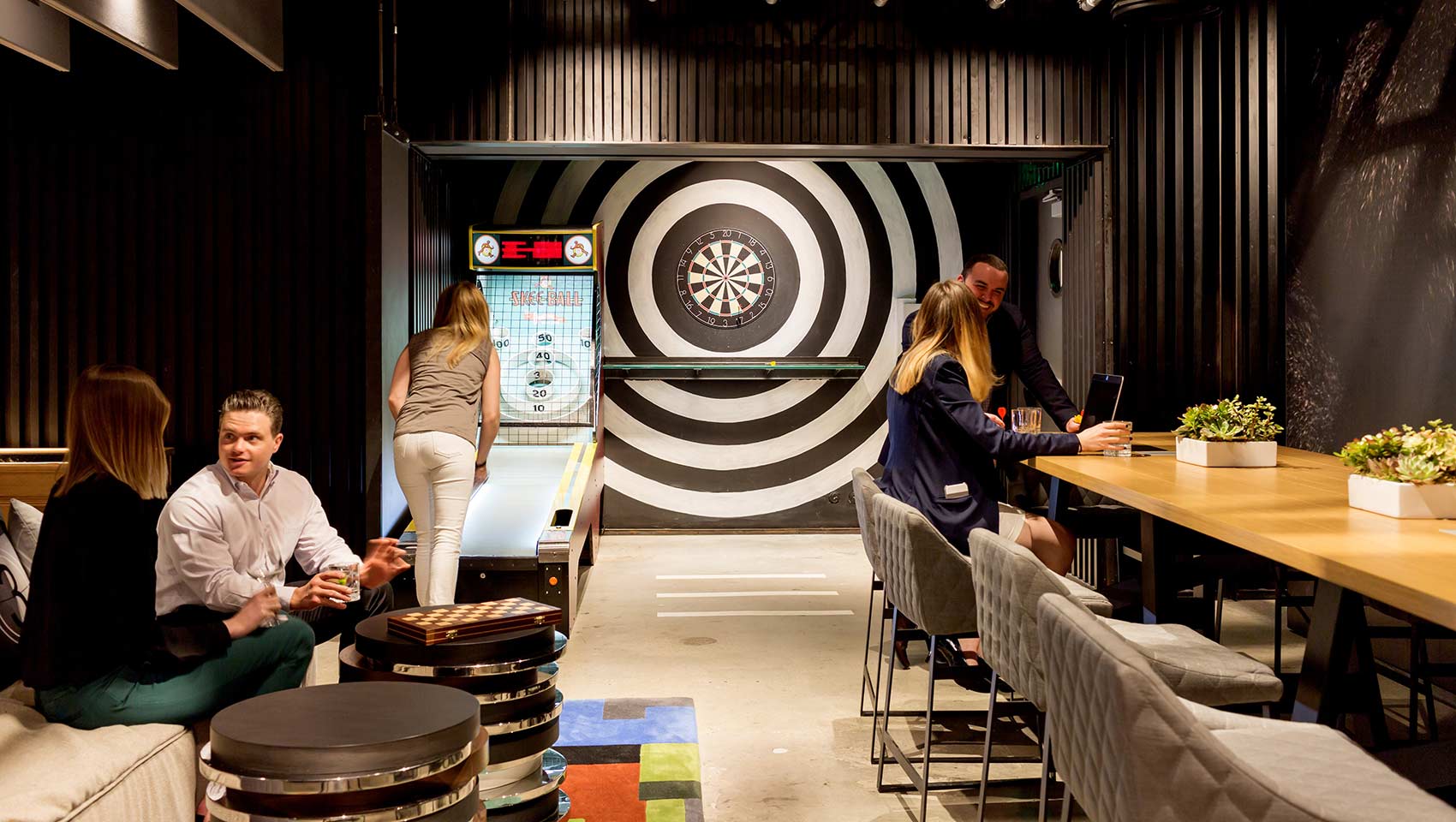 People talking and playing games in the game room at Kimpton Hotel Palomar Beverly Hills