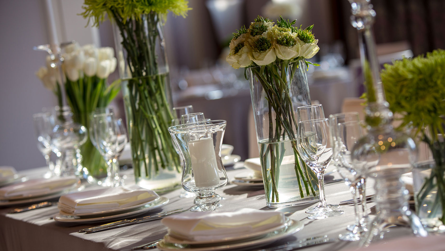 Close up of table setting with cutlery, glassware, dishes, flowers and candles, decorated for an event at Kimpton Hotel Palomar Beverly Hills